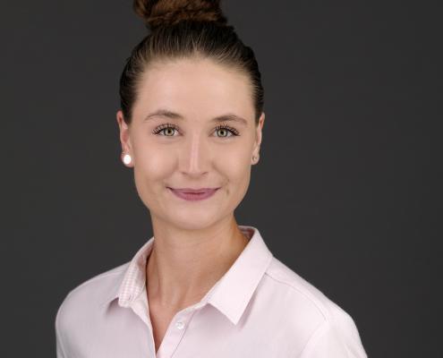 Ein hochwertiges Bewerbungsfoto Headshot Portraitfoto Frau Porträt Porträtfoto Businessfoto lächelnd vor grauem Hintergrund Bewerbungsfoto Beispielbild
